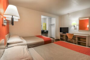 A hotel room with two single beds, a desk with a chair, a television, and a bathroom visible through an open door. - Motel 6 Chino, CA - Los Angeles Ontario (Chino)