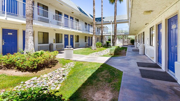 A motel with a covered walkway, multiple rooms, and a well-maintained lawn. - Motel 6 Mesa, AZ - South (Mesa)