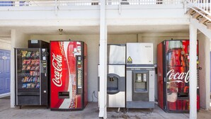 Four Coca-Cola vending machines, one with a water dispenser, and a staircase leading to an upper level. - Motel 6 Mesa, AZ - South (Mesa)