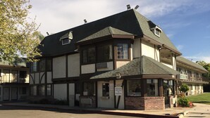 A two-story building with a dark roof and a welcoming sign. - Americas Best Value Inn North Highlands Sacramento (North Highlands)