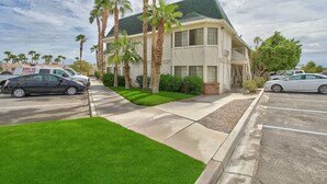 A two-story building with a green roof, surrounded by palm trees and a well-maintained lawn. - Motel 6 Yuma, AZ - East (Yuma)