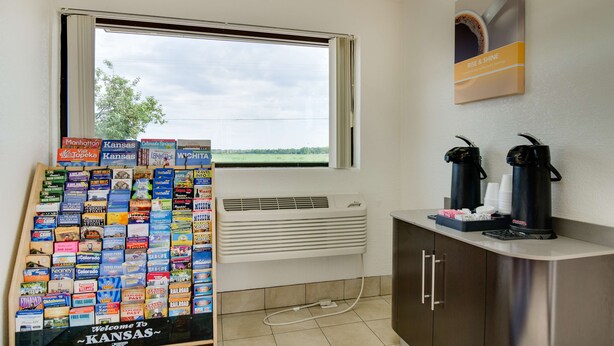 Una habitación con ventana, aire acondicionado de pared, estación de café y una selección de folletos turísticos.