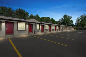 Filas de habitaciones de motel con entradas individuales y un estacionamiento.