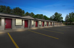 Filas de habitaciones de motel con entradas individuales y un estacionamiento.