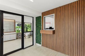 A modern reception area with a wooden panel wall, a green vertical garden, and a reception desk. - Red Roof Inn Wytheville (Wytheville)