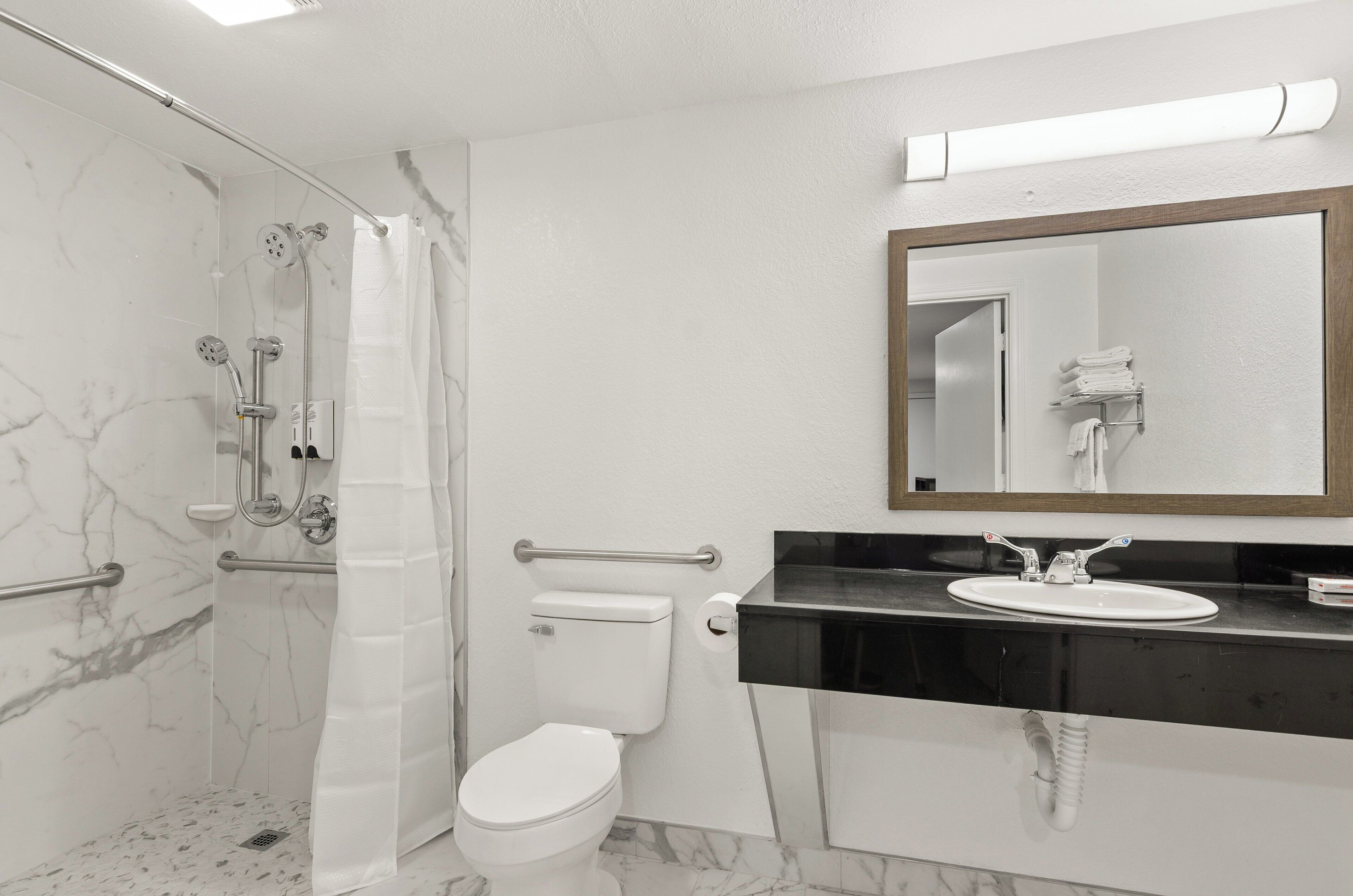 A bathroom with a shower, toilet, and sink.