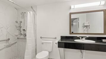 A bathroom with a shower, toilet, and sink.