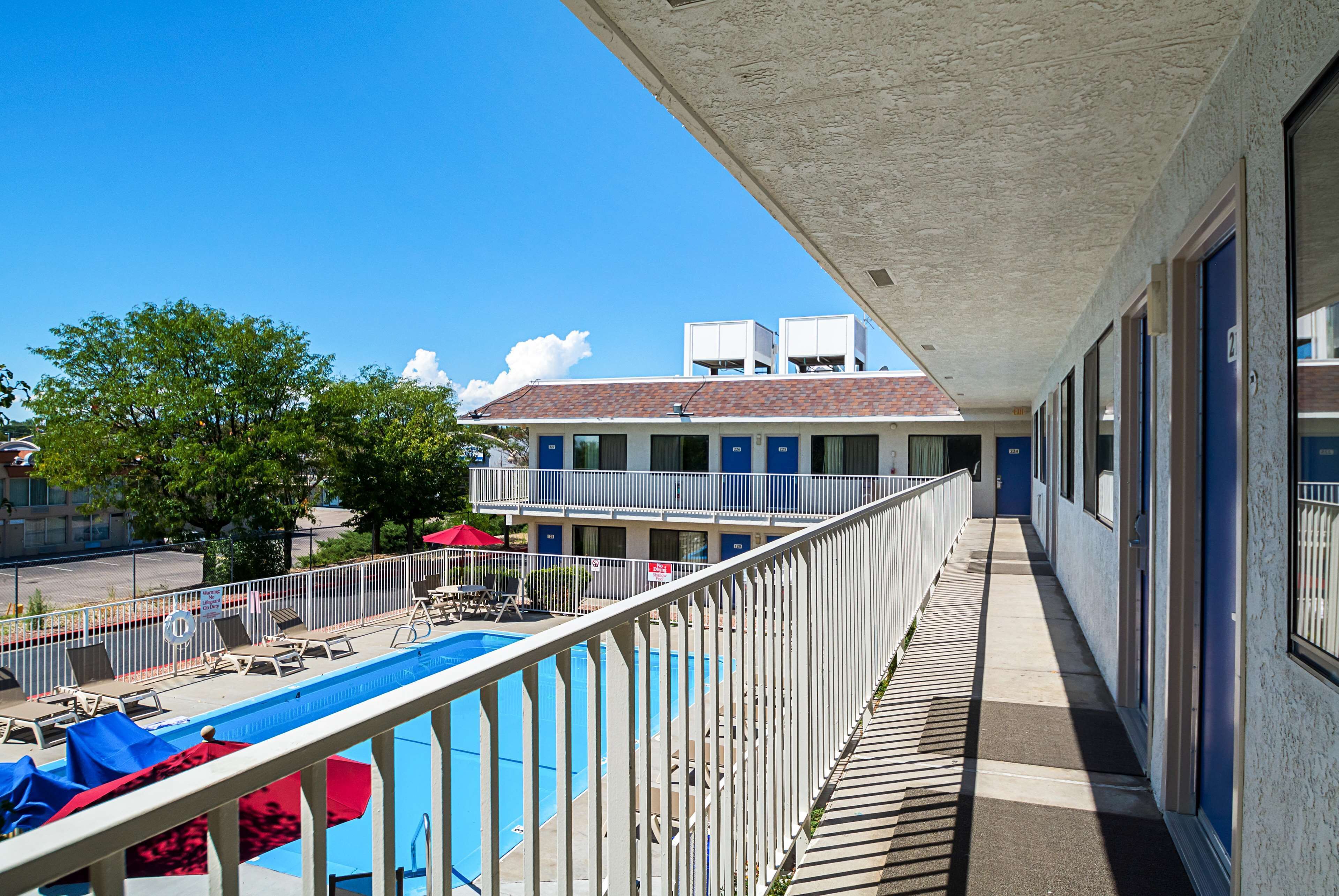 A hotel with a pool area, a balcony, and a view of the surrounding area.
