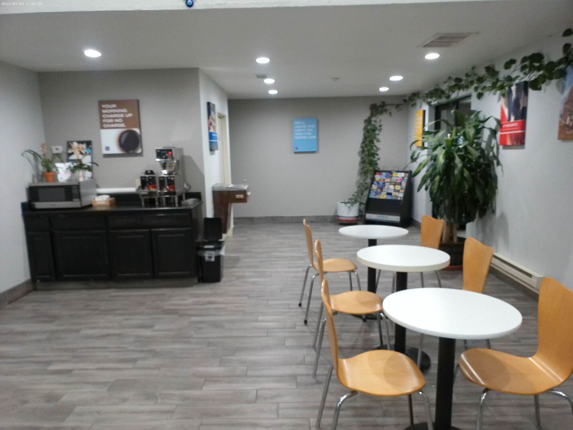 Un espace d’accueil comprenant un comptoir, des chaises, des tables et une machine à café.