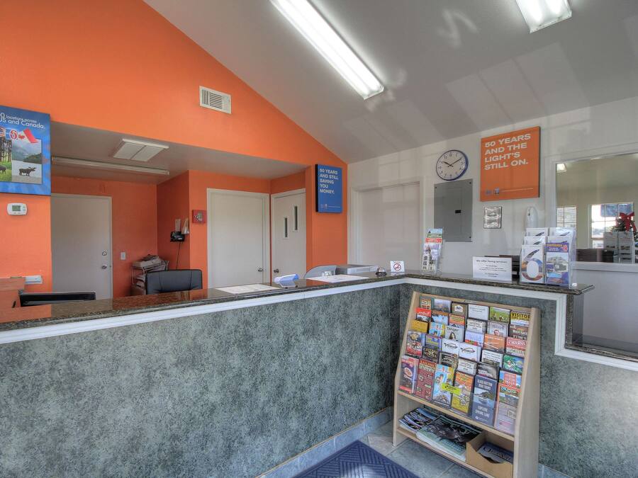 A reception area with a marble counter, a bulletin board with brochures, and a clock on the wall.