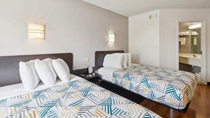 A hotel room with two beds, a nightstand, a mirror, and a bathroom visible through an open door. - Motel 6 Milan, OH - Sandusky (Milan)
