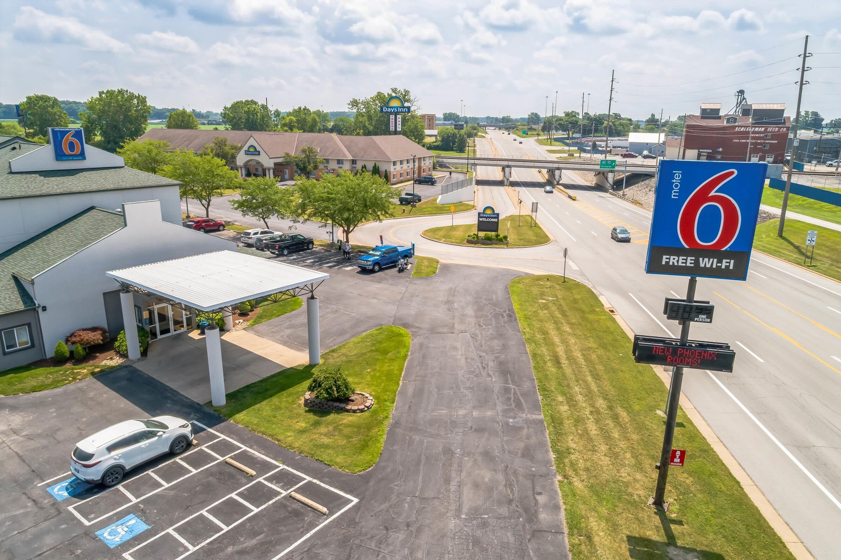 Un motel con estacionamiento, un letrero de Days Inn y un anuncio que dice '6 Wi-Fi Gratis'.