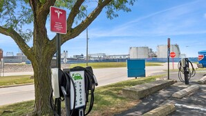 An electric vehicle charging station with a stop sign nearby. - Motel 6 Milan, OH - Sandusky (Milan)