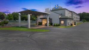 A modern hotel with a covered entrance, a handicap-accessible sign, and a parking lot. - Motel 6 Milan, OH - Sandusky (Milan)