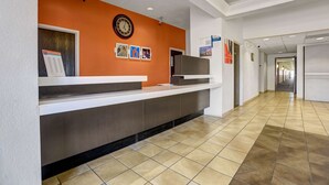 A reception area with a counter, a clock, and informational posters on the wall. - Motel 6 Benson, AZ (Benson)