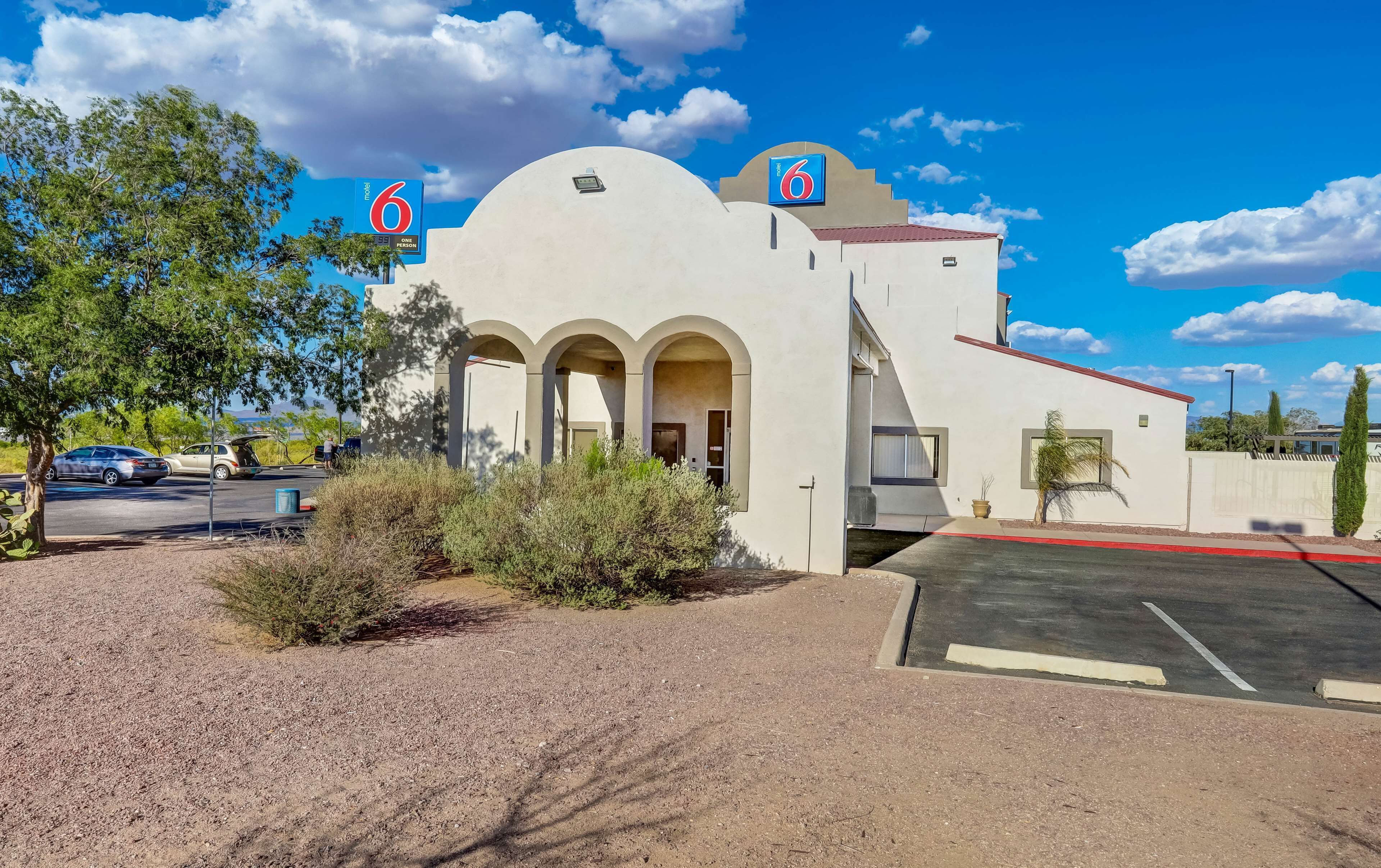 A motel with a modern design, featuring a large arched entrance and a prominent '6' sign.