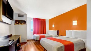 A hotel room with two beds, a desk, and a TV. - Motel 6 Benson, AZ (Benson)