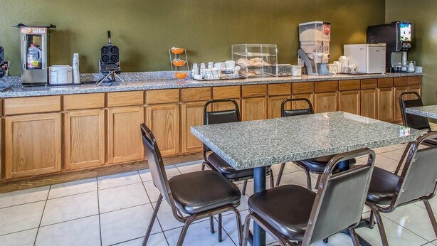 A breakfast bar with seating, a coffee machine, a microwave, and a TV.