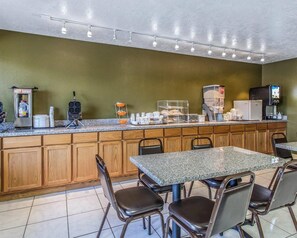 A breakfast bar with seating, a coffee machine, a microwave, and a TV. - Rodeway Inn Hurricane - Zion National Park Area (Hurricane)