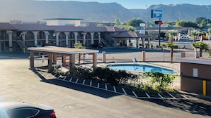 A parking lot with a pool, a building with arched windows, and a sign for Rodeway Inn.