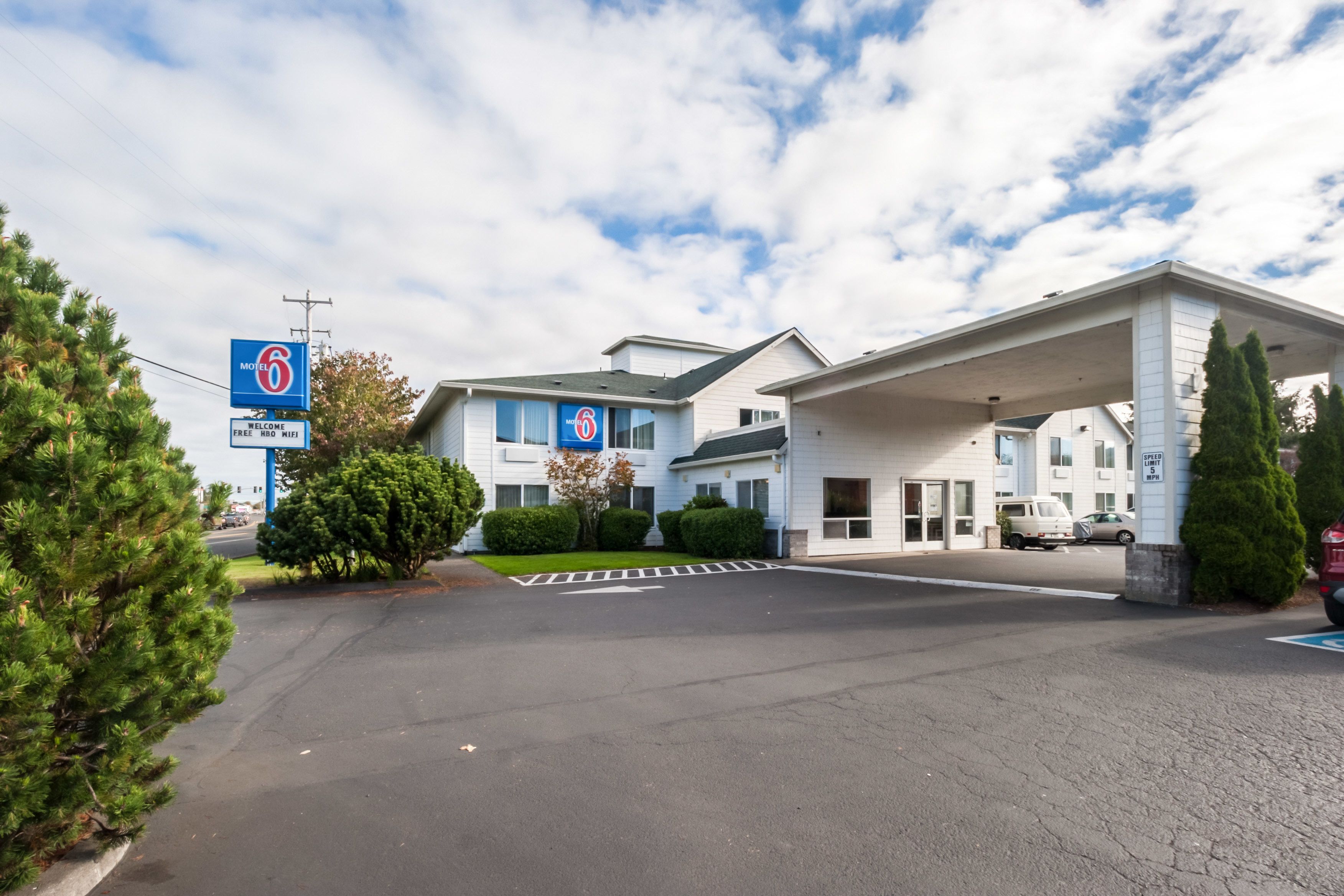 Un motel avec une station-service, un parking et un ciel dégagé.