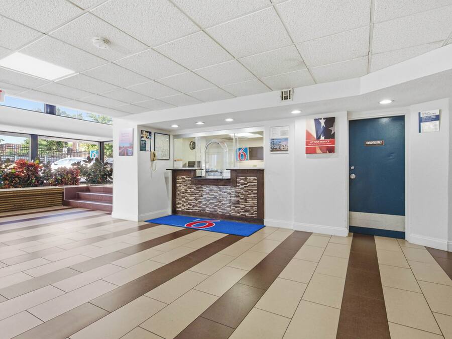 A reception area with a blue carpet, a reception desk, and a blue door marked 'Employees Only'.