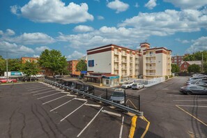 A multi-story hotel with a parking lot in front. - Motel 6 Washington, DC (Washington)