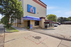 A motel with a large '6' sign, a 'WELCOME' entrance canopy, and a parking lot. - Motel 6 Washington, DC (Washington)