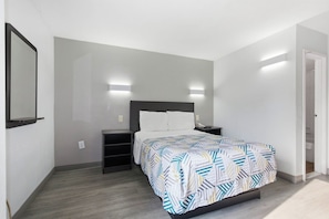 A bedroom with a bed, bedside tables, a mirror, and a wardrobe. - Motel 6 Washington, DC (Washington)