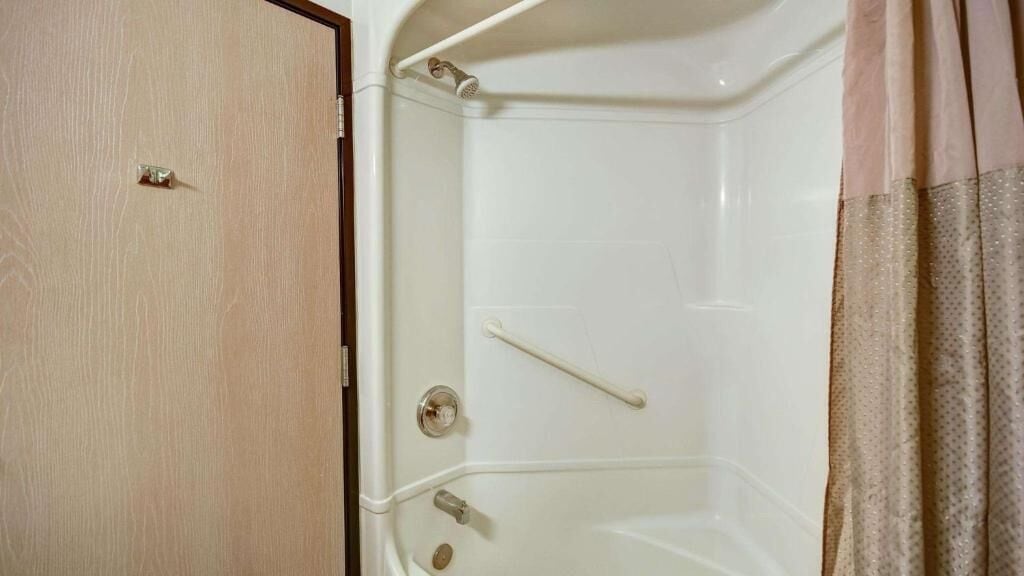 Une salle de bain avec une douche, un porte-serviettes et une porte.