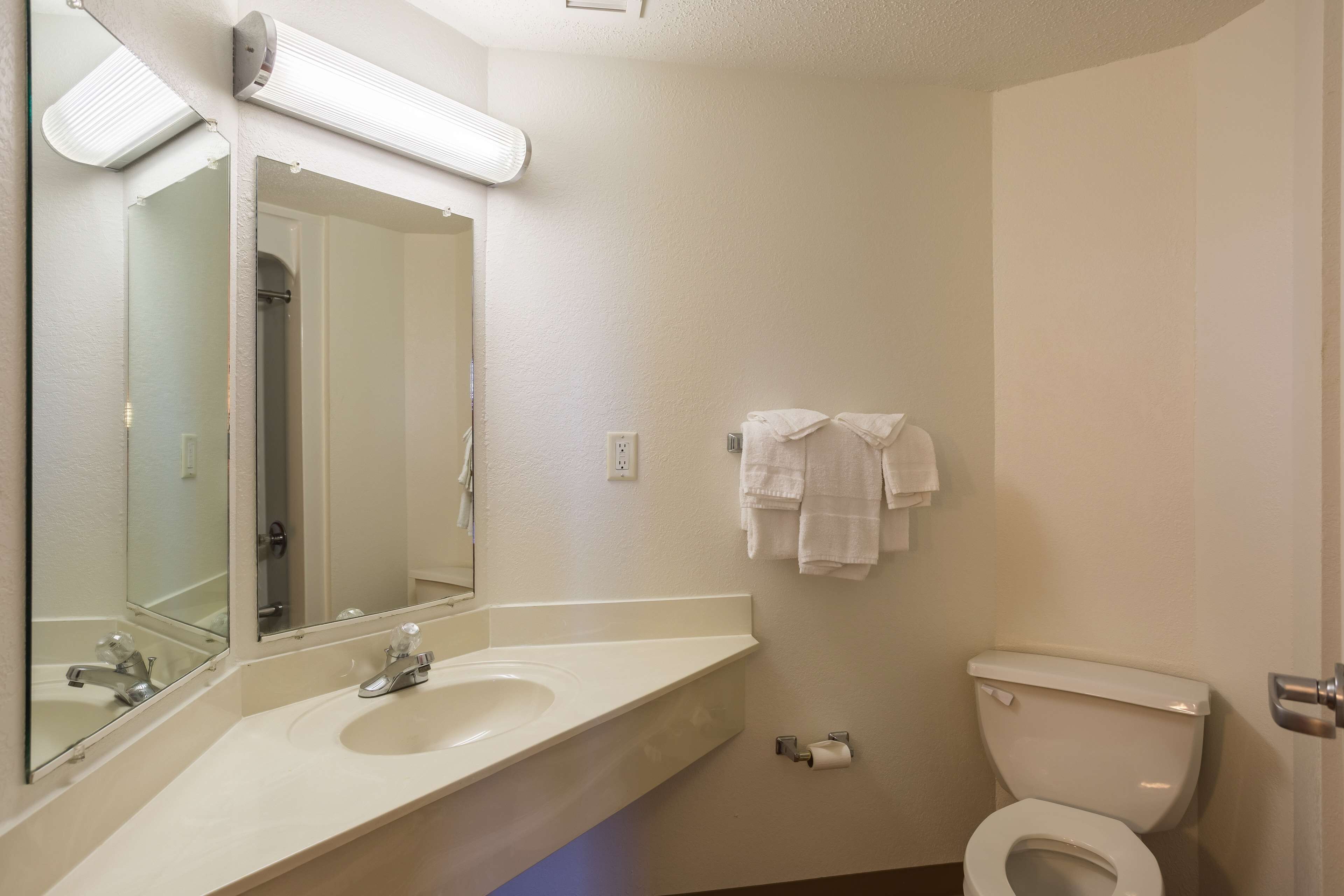 A bathroom with a sink, mirror, and toilet.