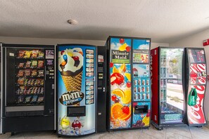 A row of vending machines with various snacks, ice cream, and drinks.
