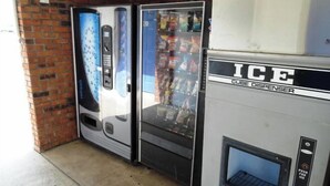 A vending machine labeled "ICE" and a beverage dispenser with a glass door. - Motel 6 Columbus, MS (Columbus)