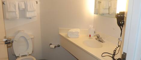 A bathroom with a toilet, sink, and towel rack.