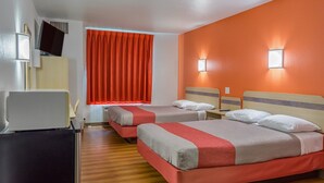 A hotel room with two beds, a desk, a chair, and a window with orange curtains. - Motel 6 Redmond, OR (Redmond)