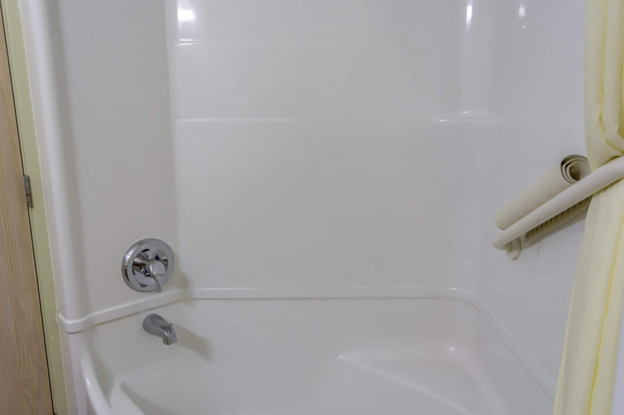 Una bañera blanca con grifo de cromo y ducha.
