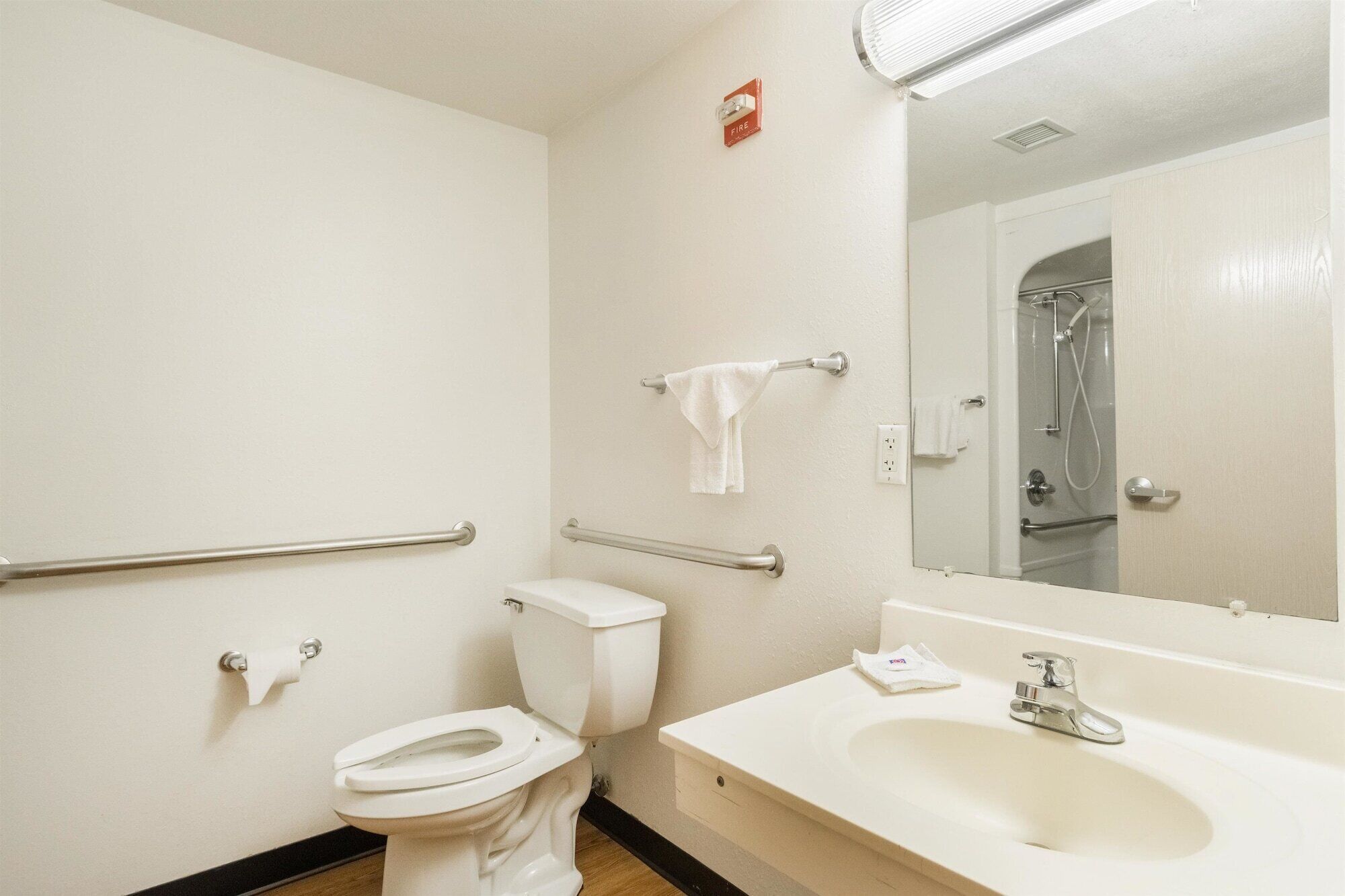 Un baño con inodoro, lavabo, espejo y ducha.