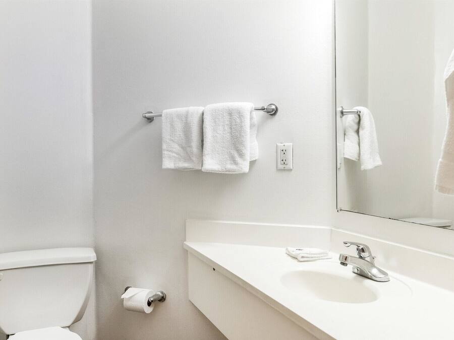 Un baño con inodoro, lavamanos y espejo.