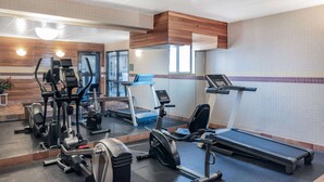 A gym with various exercise equipment, including treadmills and stationary bikes, and a mirrored wall. - Baymont by Wyndham Gillette (Gillette)