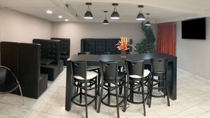 A conference room with a large table, black chairs, and a modern ceiling design. - Baymont by Wyndham Gillette (Gillette)