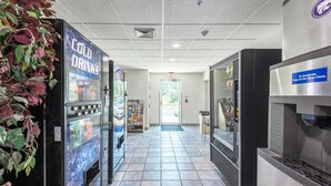 A corridor with vending machines labeled "Cold Drinks" and a coffee machine. - Motel 6 Junction City, KS (Junction City)