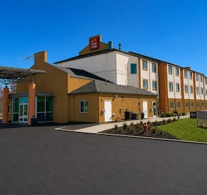 A hotel with a modern design, featuring a prominent entrance, a covered outdoor seating area, and a well-maintained lawn. - Econo Lodge Menomonie (Menomonie)