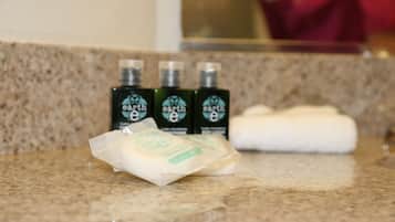 Tocador de baño con tres botellas de jabón Earth y una barra de jabón.