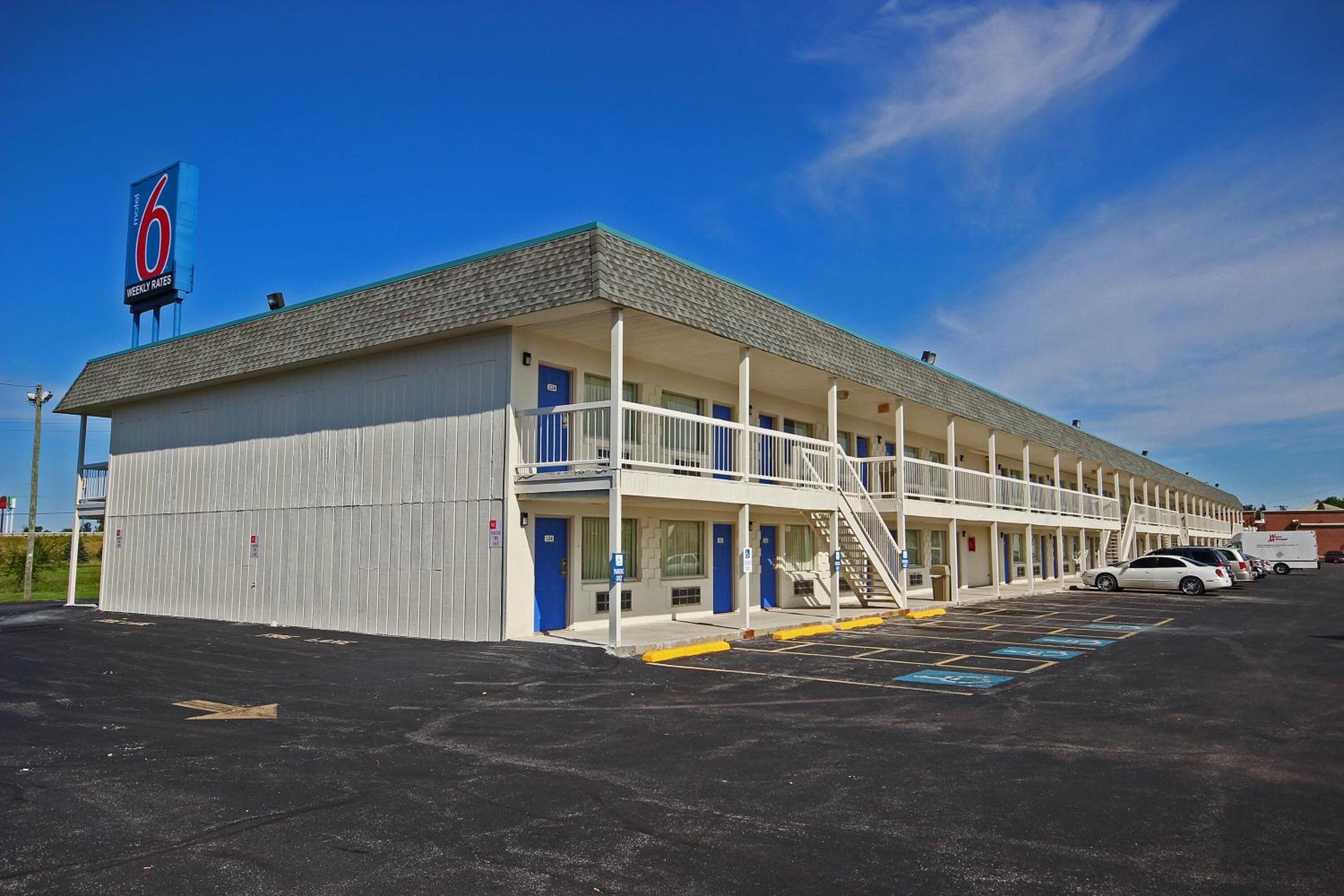Un motel composé d’un bâtiment à deux étages, d’un porche avant couvert et d’un parking.