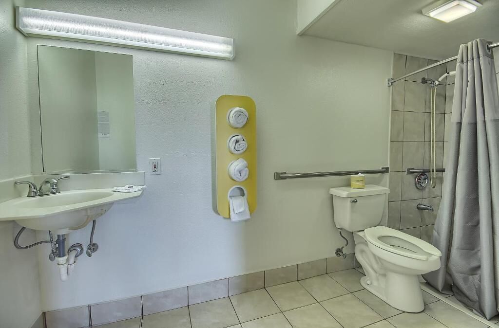 Un baño con lavabo, espejo, inodoro y ducha.