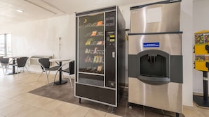 Máquina expendedora con aperitivos y dispensador de agua en el vestíbulo de un hotel.