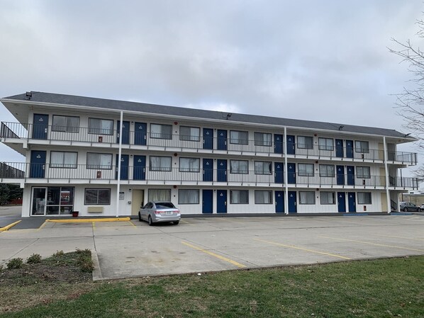A multi-story motel with a parking lot in front. - Motel 6 Dayton, OH (Dayton)