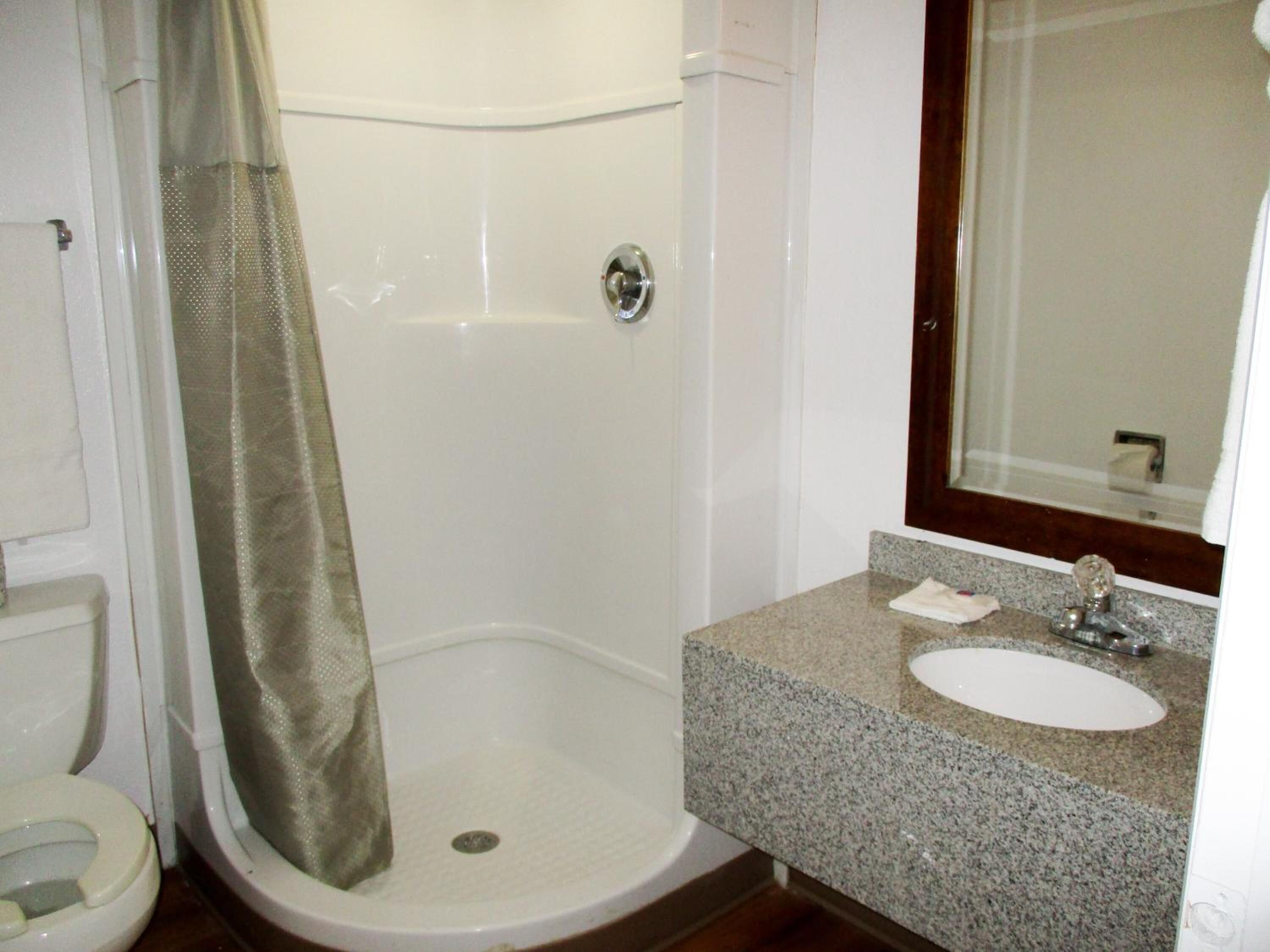 A bathroom with a shower, toilet, and sink.
