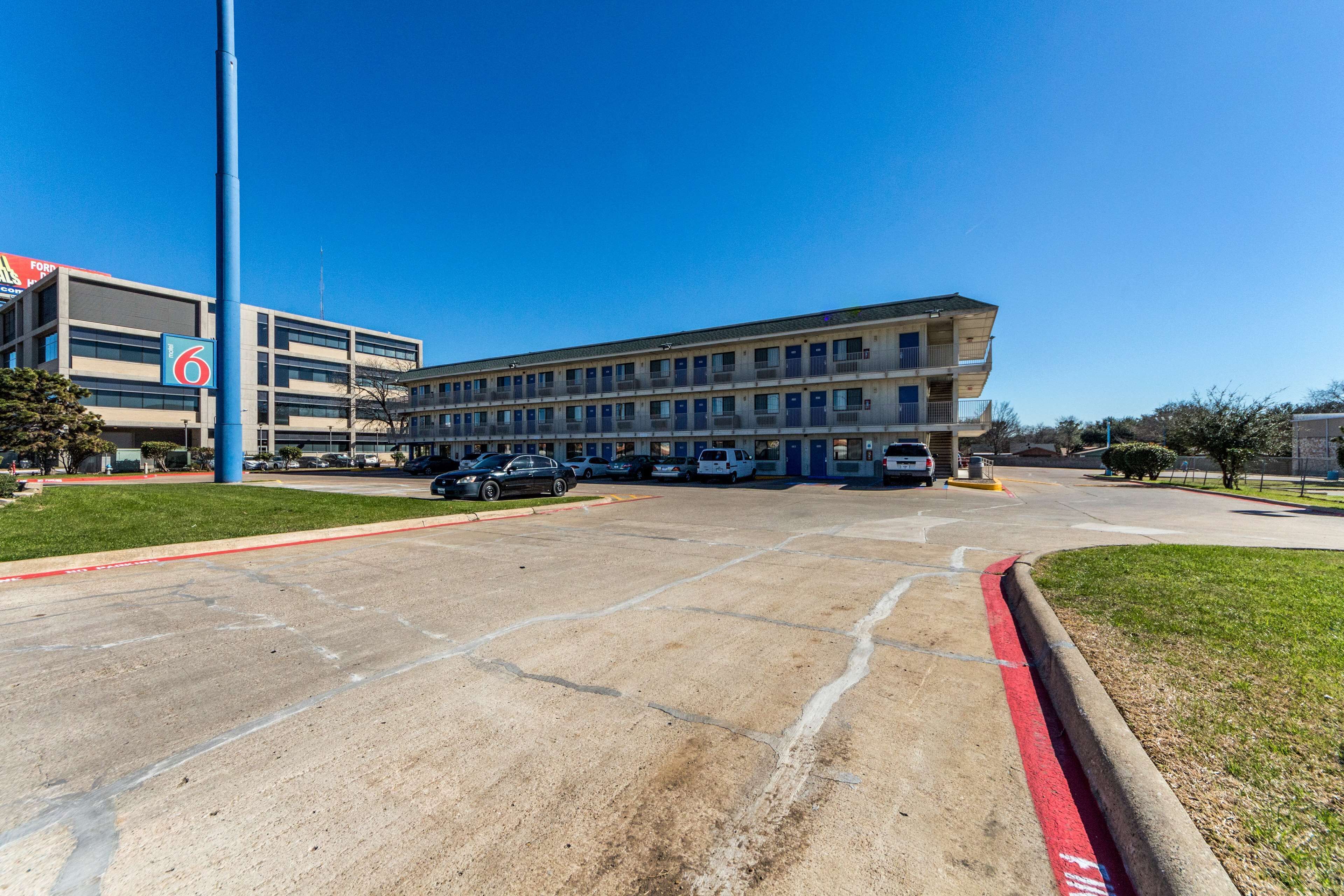 A multi-story building with a parking lot in front.