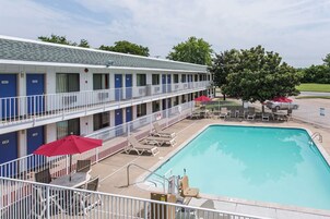 Un motel con piscina, varias habitaciones y zona de estar al aire libre.